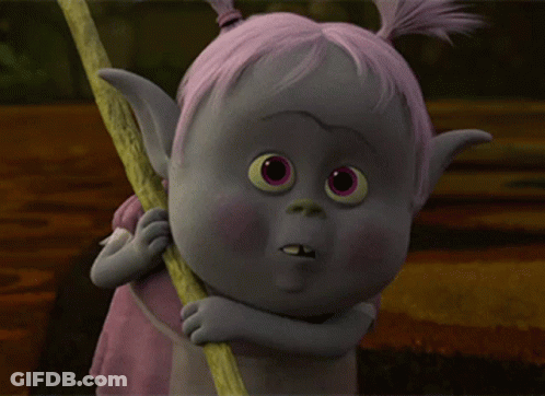 A Troll With Pink Hair Is Holding A Stick And Making A Funny Face GIF
