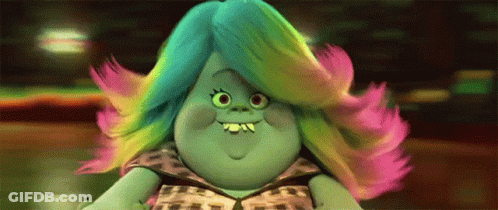 A Troll With Rainbow Hair Is Smiling And Wearing A Leopard Print Dress . GIF