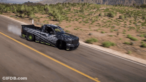 A Truck Is Driving Down A Desert Road With Smoke Coming Out Of The Tires GIF