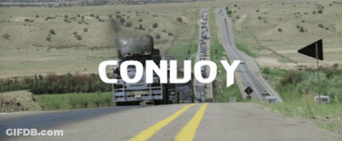 A Truck Is Driving Down A Highway With The Word Conuoy Written On It GIF