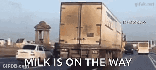 A Truck Is Driving Down A Highway With The Words Milk Is On The Way Written On The Bottom GIF