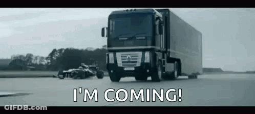 A Truck Is Driving Down A Road Next To A Race Car . GIF