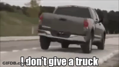 A Truck Is Driving Down A Road With The Words `` I Don T Give A Truck '' Written On It . GIF