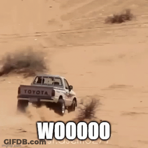 A Truck Is Driving Down A Sand Dune And The Words Woooom Are On The Bottom GIF