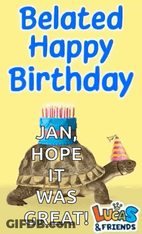 A Turtle Wearing A Party Hat Is Sitting On Top Of A Cake . GIF