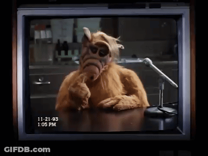 A Tv Screen Shows Alf Talking Into A Microphone GIF