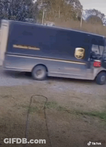 A Ups Truck Is Pulling A Trailer With Dogs Behind It GIF