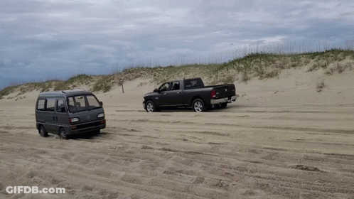 A Van And A Truck Are Parked In The Sand GIF