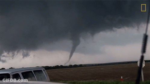 A Van Is Parked In Front Of A Tornado With A National Geographic Logo In The Corner GIF