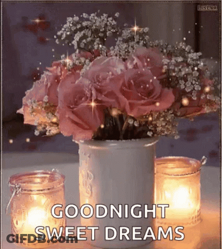 A Vase Filled With Pink Roses And Baby 'S Breath Next To Candles . GIF