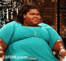 A Very Fat Woman In A Blue Shirt Is Sitting On A Chair . GIF