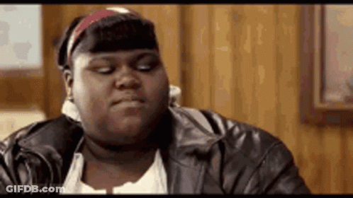 A Very Fat Woman Wearing A Leather Jacket And A Headband Is Sitting In A Room . GIF