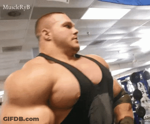 A Very Large Man Is Standing In A Gym With A Lot Of Muscles . GIF