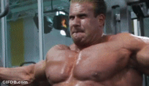 A Very Muscular Man Is Sitting On A Machine In A Gym With His Arms Outstretched . GIF