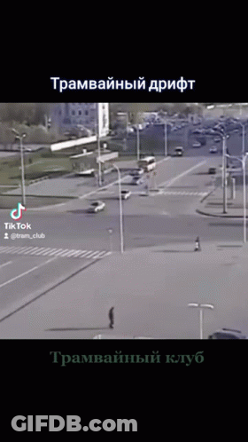 A Video Of A Man Walking Down A Street In A City With Russian Writing On The Bottom GIF