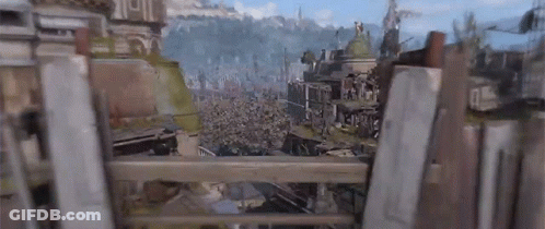 A View Of A City From Behind A Wooden Fence With A Mountain In The Background . GIF