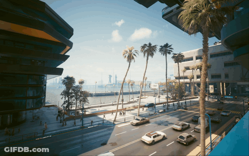 A View Of A City Street With Palm Trees And Buildings GIF