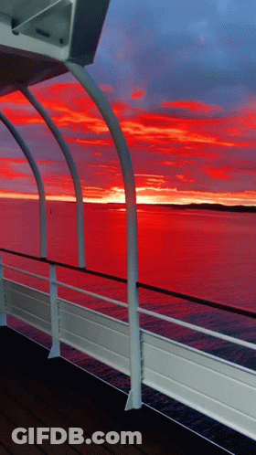 A View Of A Sunset From A Boat Deck GIF
