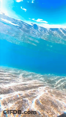 A View Of The Ocean From The Bottom Of The Sand GIF