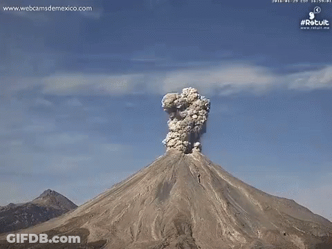 A Volcano Is Erupting With A Huge Cloud Of Smoke Coming Out Of It GIF