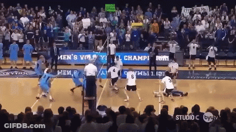 A Volleyball Game Is Being Played In Front Of A Crowd With A Sign That Says Men 'S Volleyball Champions GIF