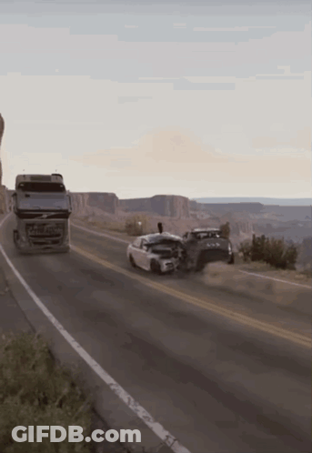 A Volvo Truck Is Driving Down The Road Next To A Car GIF
