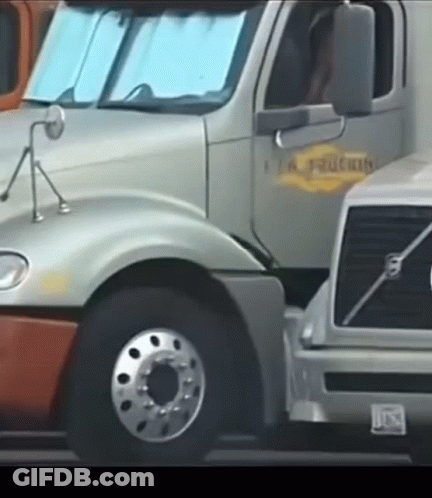 A Volvo Truck Is Parked Next To A Silver Truck GIF