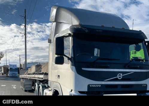 A Volvo Truck Is Parked On The Side Of A Road GIF