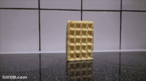 A Waffle Is Sitting On A Counter With A Tiled Wall Behind It GIF