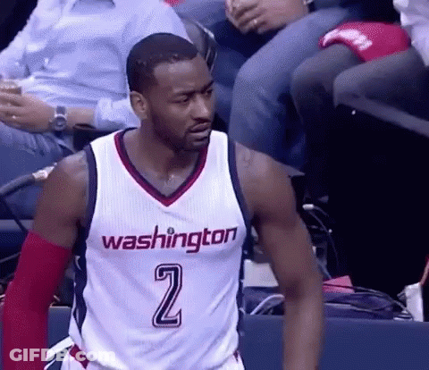 A Washington Wizards Basketball Player Is Standing On The Court In Front Of A Crowd . GIF