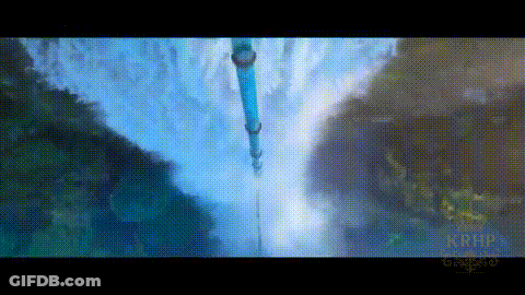 A Waterfall Is Surrounded By Mountains And Trees And A Blue Pipe Is Hanging Over It . GIF