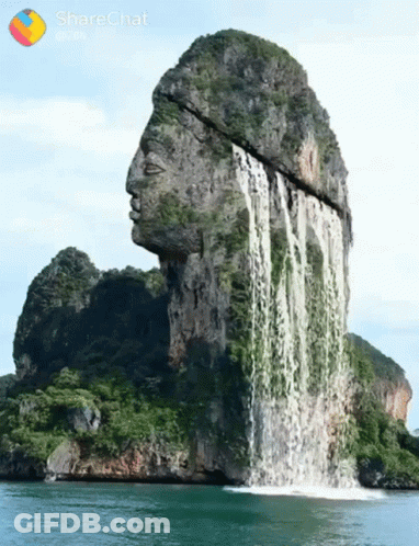 A Waterfall That Looks Like A Statue Of A Man 'S Head GIF