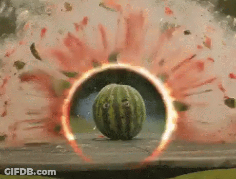 A Watermelon Is Exploding On A Table With A Red Circle Around It . GIF
