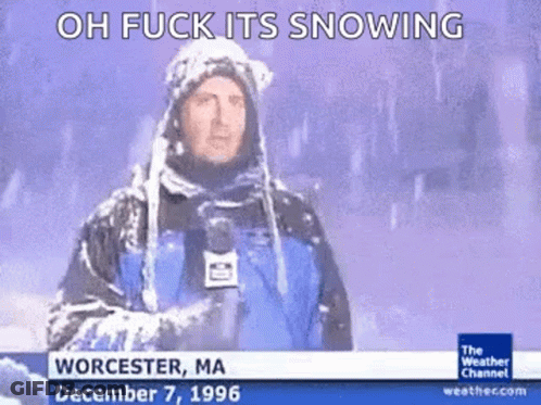 A Weatherman Is Standing In The Snow Holding A Microphone GIF
