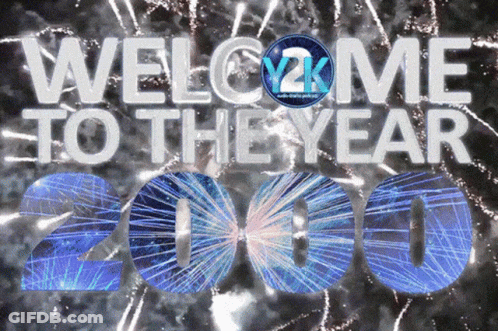 A Welcome To The Year 2000 Sign With Fireworks Behind It GIF