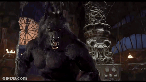 A Werewolf Is Standing In Front Of A Ferris Wheel And A Statue GIF
