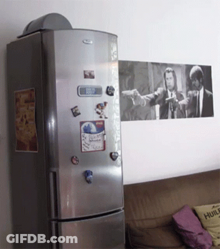 A Whirlpool Refrigerator With A Picture Of Pulp Fiction On The Wall Above It GIF