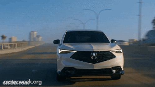 A White Acura Car Is Driving Down A Highway With Motorweek.org Written On The Bottom GIF
