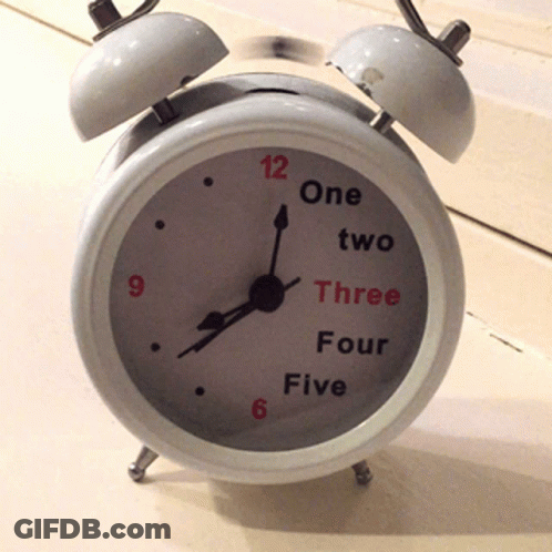 A White Alarm Clock That Says One Two Three Four And Five On The Face GIF