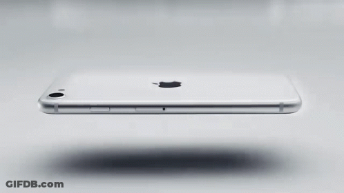 A White Apple Iphone Is Floating On A White Surface . GIF