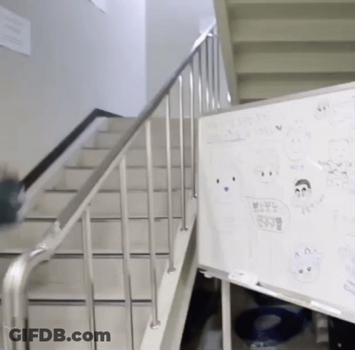A White Board With Drawings On It Is Next To A Railing And Stairs GIF