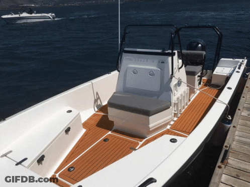 A White Boat With A Yamaha Motor Sits On A Dock GIF