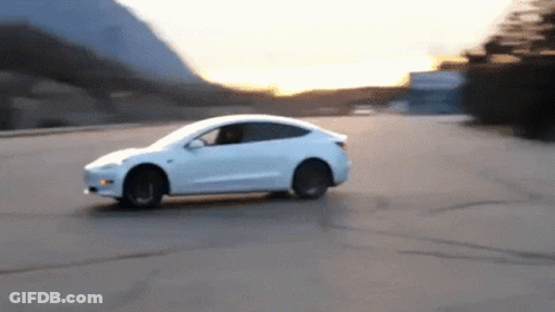 A White Car Driving Down A Road With Mountains In The Background GIF