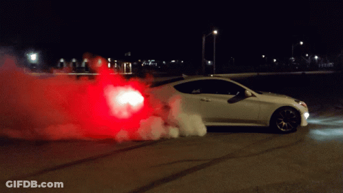 A White Car Is Doing A Burnout At Night With Red Smoke Coming Out Of The Back GIF