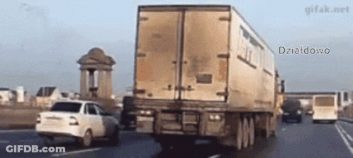 A White Car Is Driving Down A Highway Next To A Large Truck That Says Dziatdowo GIF