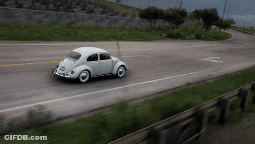 A White Car Is Driving Down A Road With The Letter Z On The Side Of It GIF