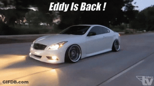 A White Car Is Driving Down A Road With The Words " Eddy Is Back " On The Bottom GIF
