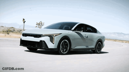 A White Car Is Driving On A Road With Mountains In The Background GIF
