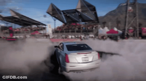 A White Car Is Driving Through A Dirt Field GIF