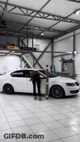 A White Car Is Parked In A Garage With A Tiktok Sticker GIF